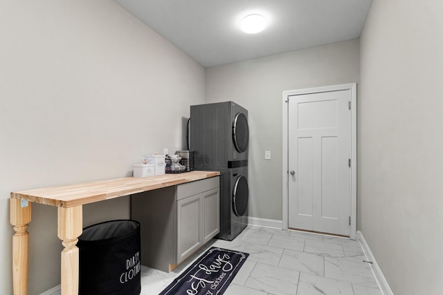 washroom featuring cabinets and stacked washer / drying machine