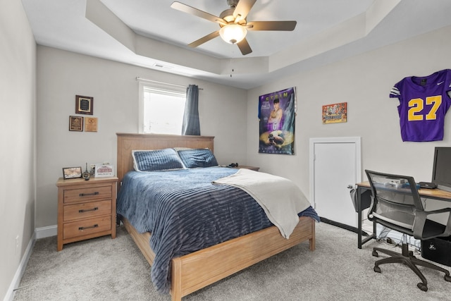 bedroom featuring a tray ceiling, ceiling fan, and light colored carpet