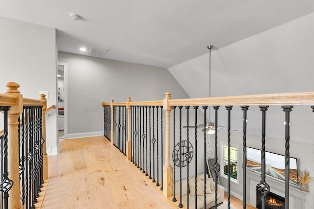 hallway featuring hardwood / wood-style flooring and vaulted ceiling