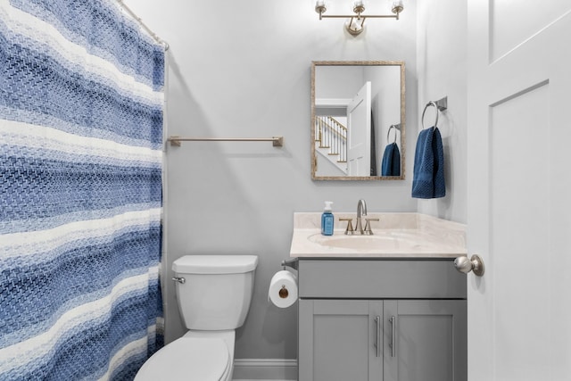 bathroom featuring walk in shower, vanity, and toilet