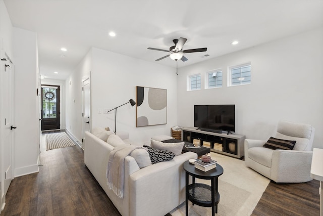 living room with dark hardwood / wood-style flooring and ceiling fan