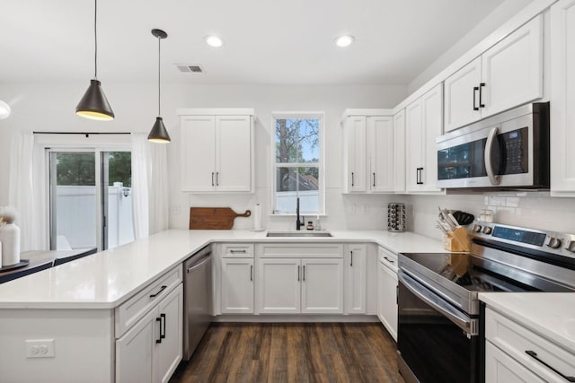 kitchen with white cabinets, sink, kitchen peninsula, and stainless steel appliances