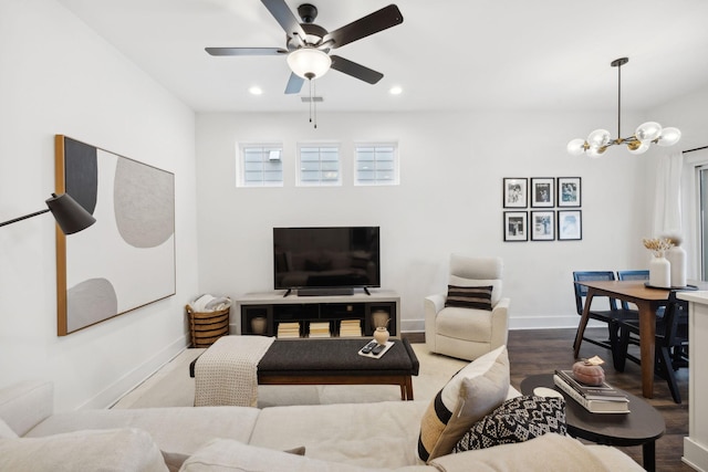 living room with hardwood / wood-style floors and ceiling fan with notable chandelier