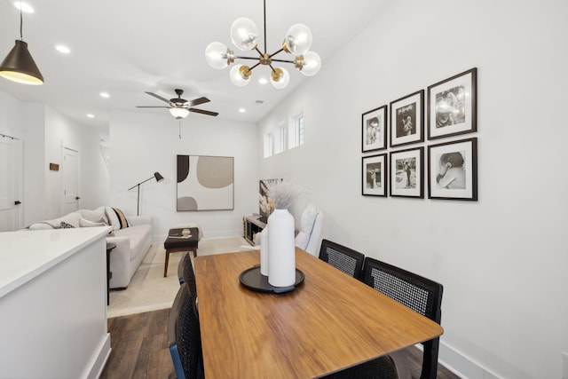 dining room featuring dark hardwood / wood-style flooring and ceiling fan with notable chandelier