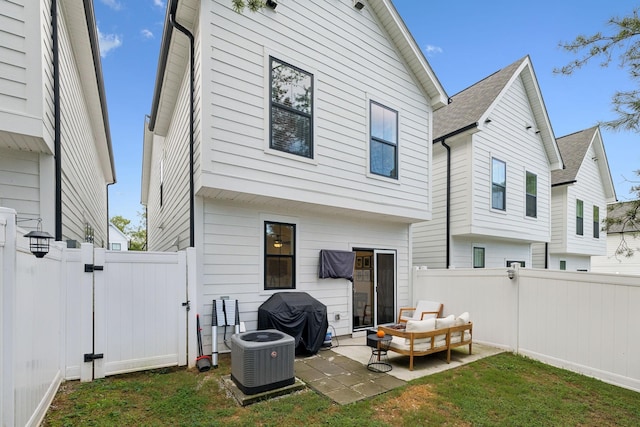 back of house featuring a yard, a patio, an outdoor living space, and central AC