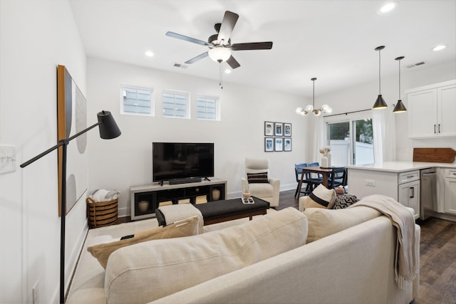 living room featuring ceiling fan with notable chandelier and dark hardwood / wood-style floors