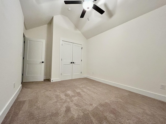 unfurnished bedroom with carpet flooring, ceiling fan, a closet, and vaulted ceiling