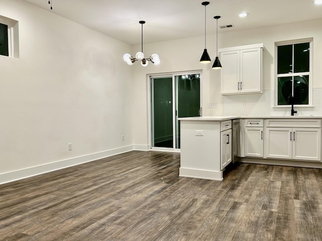 kitchen with white cabinets, backsplash, a notable chandelier, and sink