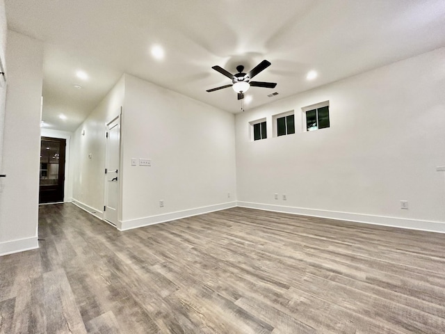 empty room with ceiling fan and hardwood / wood-style flooring