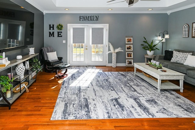 living room with hardwood / wood-style flooring, ornamental molding, and french doors