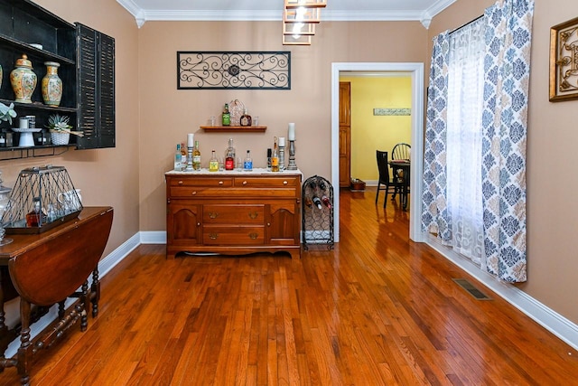 bar featuring dark wood-type flooring and ornamental molding