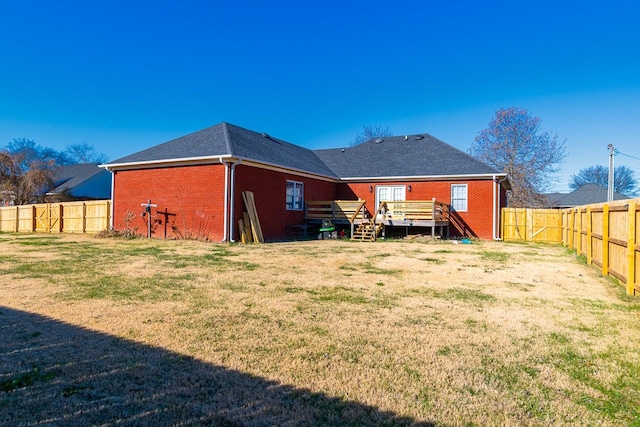 rear view of property with a yard and a deck