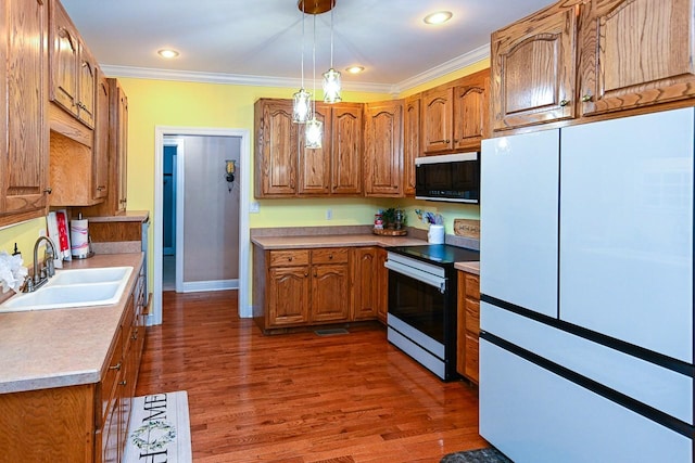 kitchen featuring sink, crown molding, dark hardwood / wood-style flooring, pendant lighting, and stainless steel electric stove