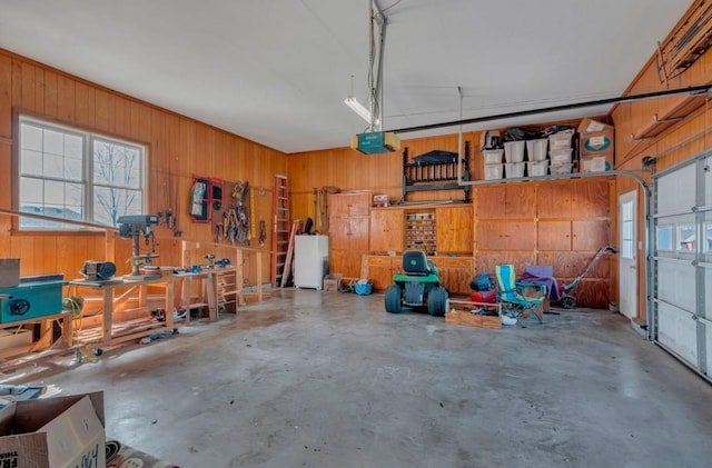 garage with a garage door opener, a workshop area, and wood walls