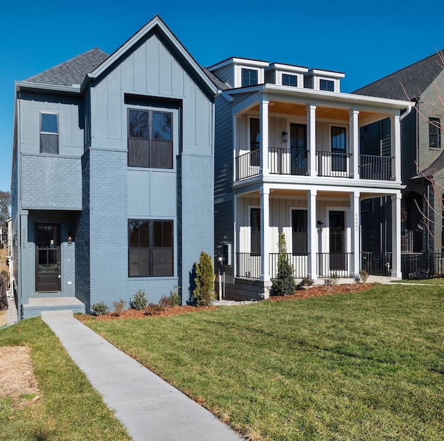 view of front of property featuring a front lawn and a balcony