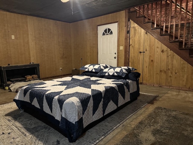 bedroom featuring wood walls and concrete flooring