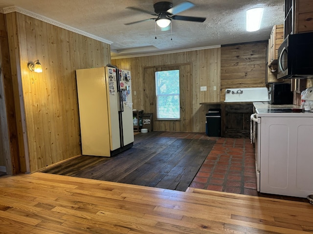 kitchen featuring range, wooden walls, dark hardwood / wood-style flooring, and white refrigerator