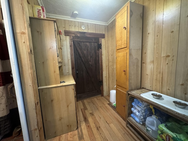 interior space featuring hardwood / wood-style flooring, ornamental molding, and wood walls