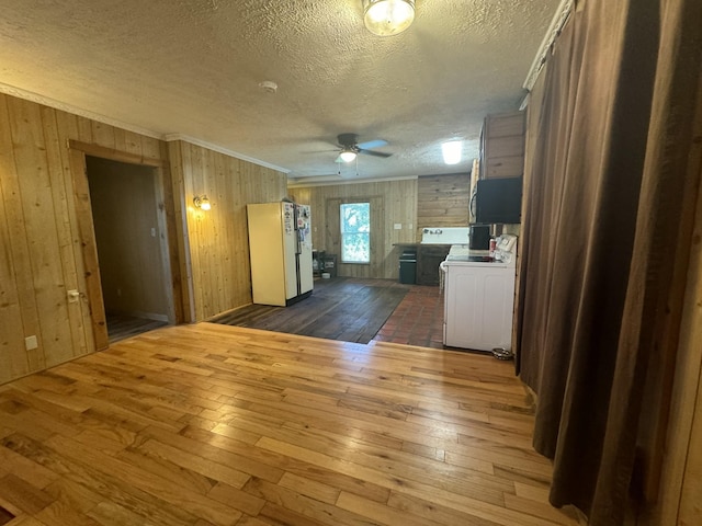 kitchen with white refrigerator, wooden walls, ceiling fan, dark hardwood / wood-style floors, and a textured ceiling