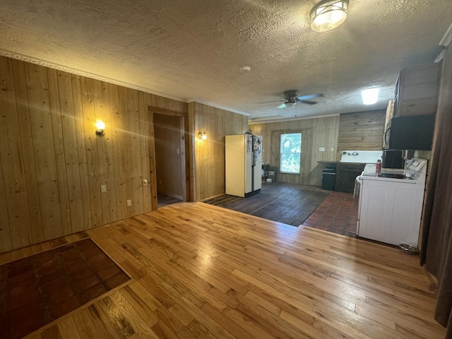 interior space featuring washer / clothes dryer, dark hardwood / wood-style floors, and wooden walls