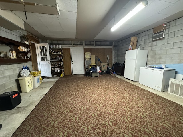 basement featuring white refrigerator and refrigerator