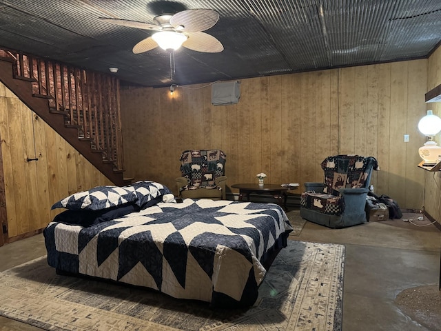 bedroom featuring concrete floors, ceiling fan, and wooden walls