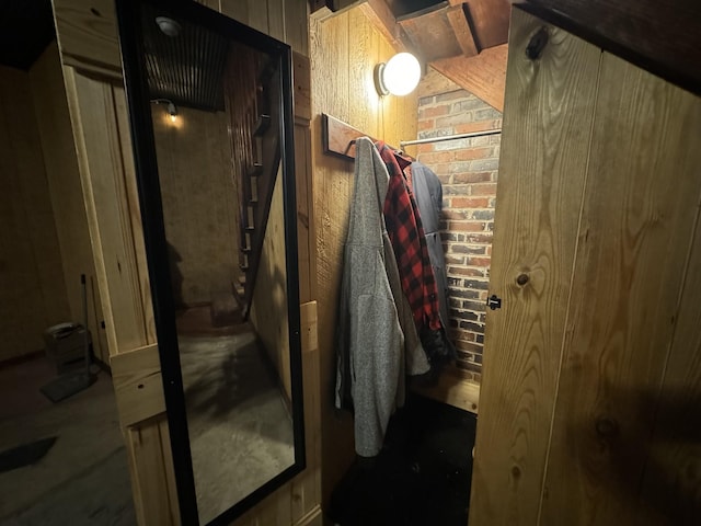 interior space with wooden walls and brick wall