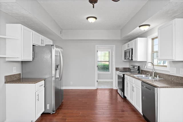 kitchen featuring appliances with stainless steel finishes, dark hardwood / wood-style floors, white cabinetry, and sink