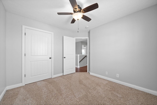 unfurnished bedroom with ceiling fan and carpet