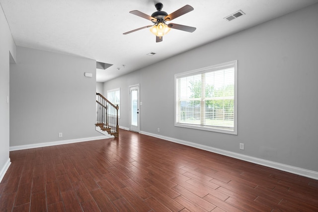 unfurnished living room featuring ceiling fan and dark wood-type flooring