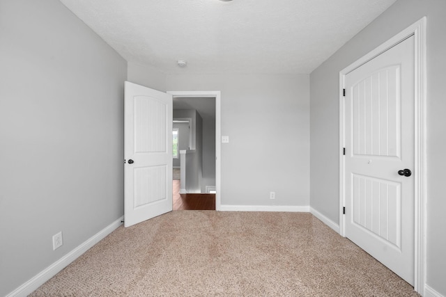 unfurnished bedroom featuring carpet flooring and a textured ceiling