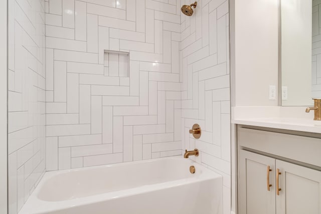 bathroom featuring tiled shower / bath combo and vanity