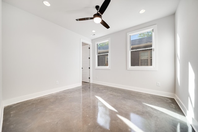 spare room featuring ceiling fan and concrete floors