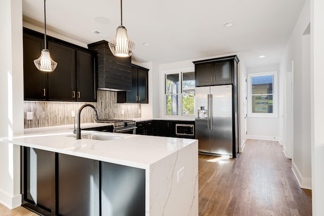 kitchen with backsplash, light stone counters, hanging light fixtures, and high end appliances