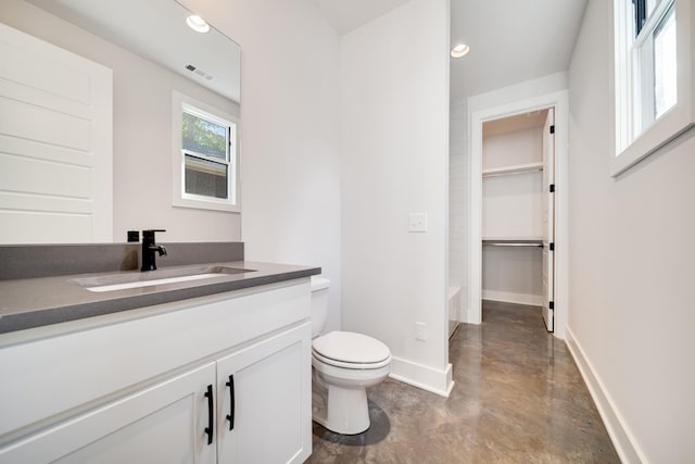 bathroom with a bath, vanity, and toilet