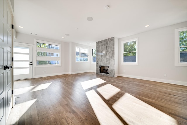 unfurnished living room with a large fireplace and wood-type flooring