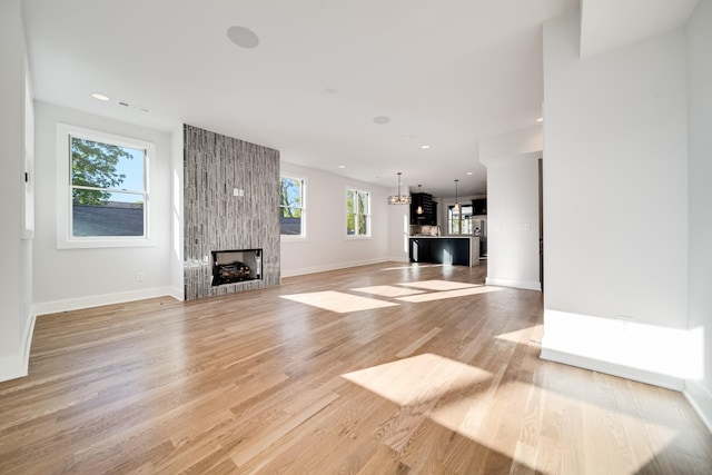 unfurnished living room with plenty of natural light, light hardwood / wood-style floors, and a fireplace