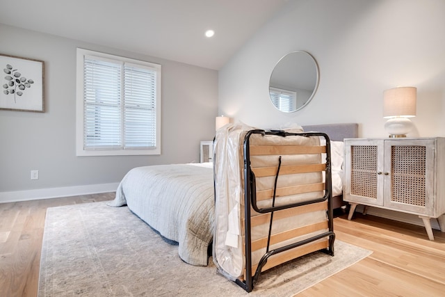 bedroom with light hardwood / wood-style floors and vaulted ceiling