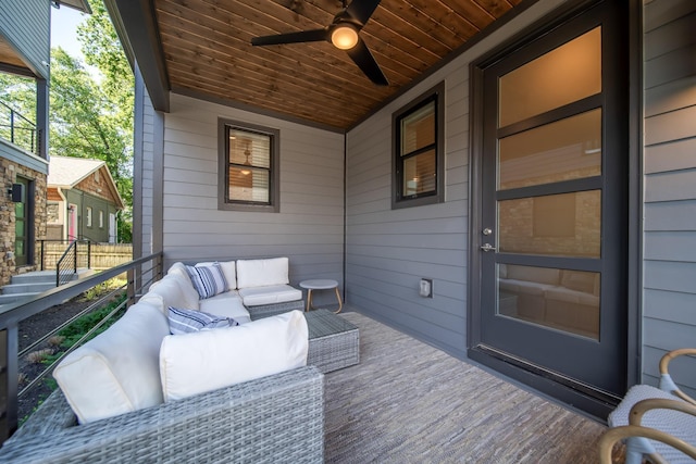 wooden deck with outdoor lounge area and ceiling fan