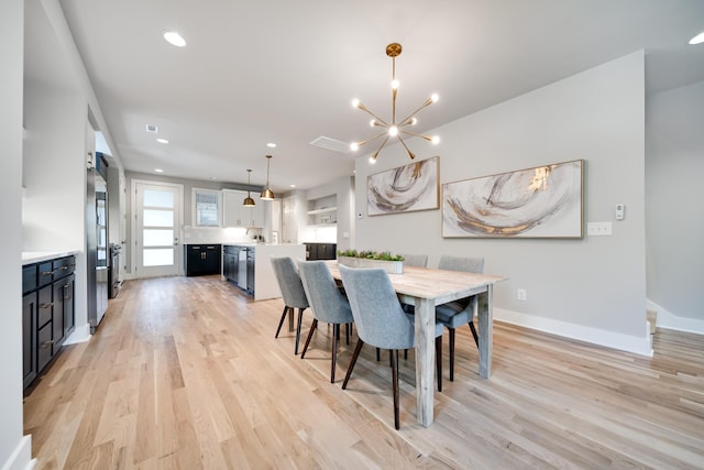 dining space with an inviting chandelier and light hardwood / wood-style flooring