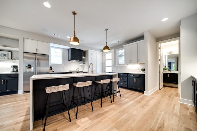 kitchen featuring white cabinets, a wealth of natural light, and high quality fridge