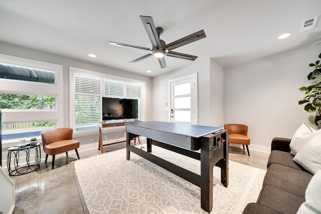 game room with ceiling fan and concrete floors