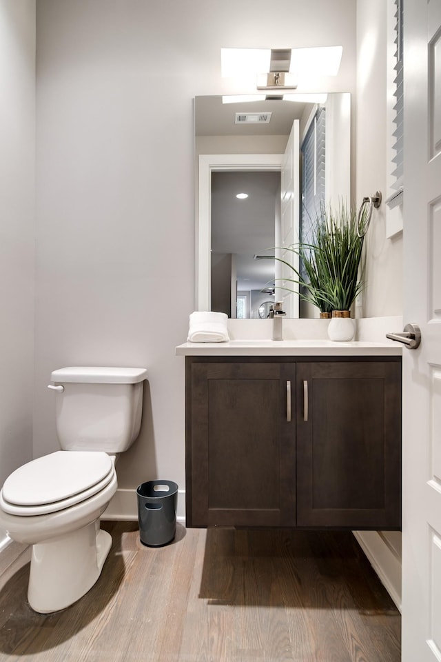 bathroom with vanity, wood-type flooring, and toilet