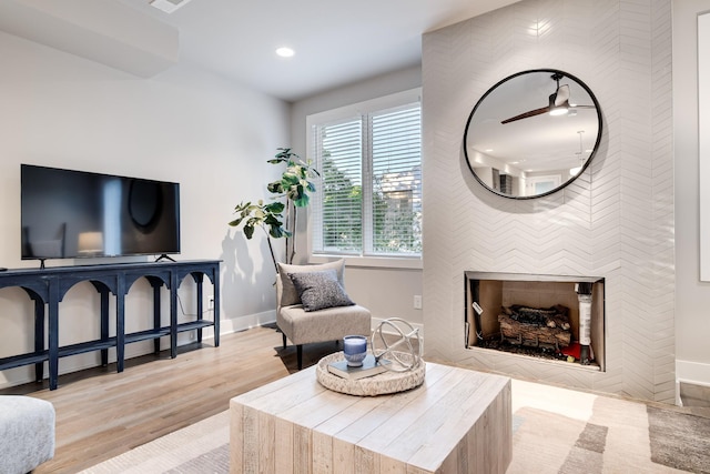 living room with light hardwood / wood-style flooring and ceiling fan