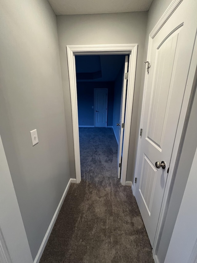 hall featuring dark carpet