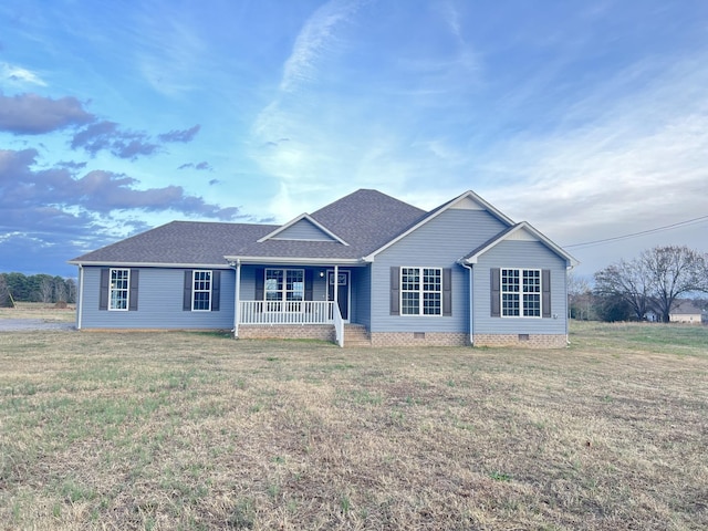 ranch-style house featuring covered porch and a front yard