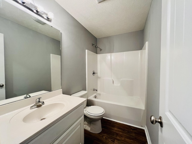 full bathroom featuring tub / shower combination, a textured ceiling, toilet, vanity, and hardwood / wood-style flooring