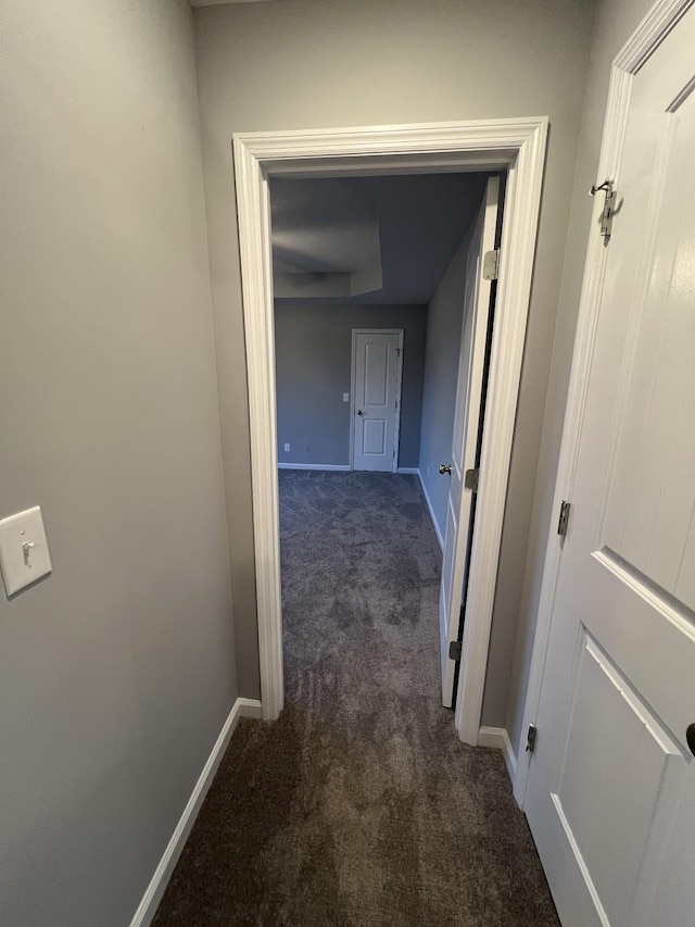 hallway featuring dark carpet