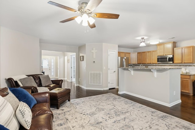 living room with ceiling fan and dark wood-type flooring