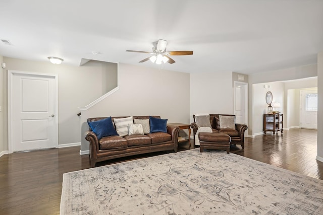 living room featuring ceiling fan and dark wood-type flooring